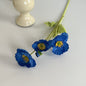 realistic faux silk poppy flowers in royal blue color on an aesthetic grey background