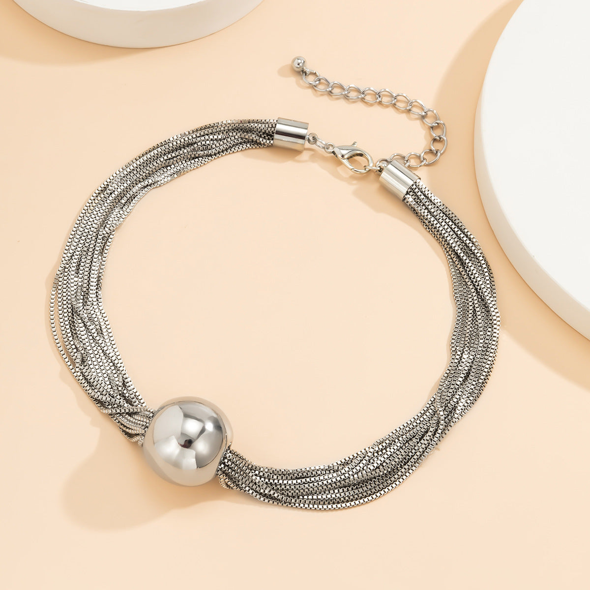 elegant minimalist multi strand layered chain necklace with metal beads on a clean background