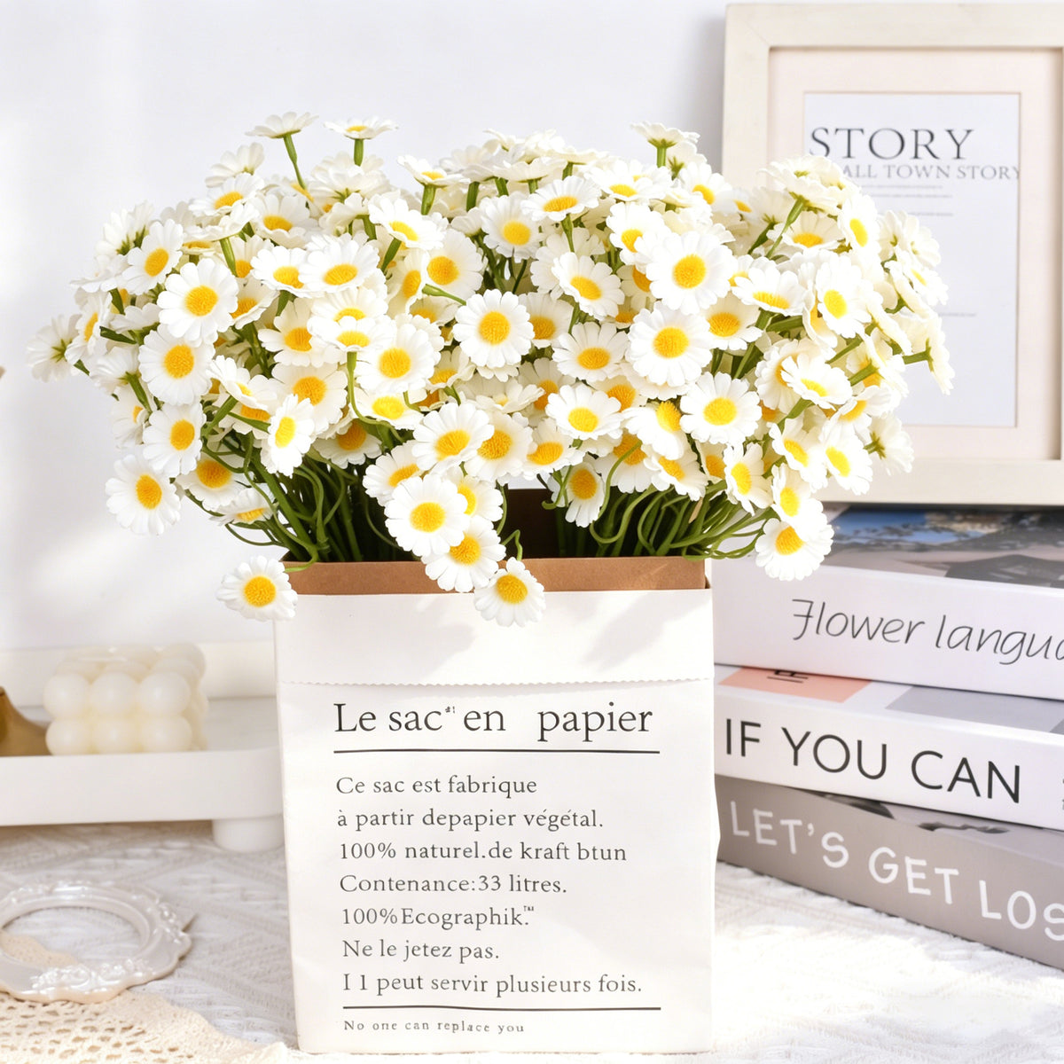 realistic artificial daisy chamomile bouquet arranged in a french paper bag inside a cozy home setting