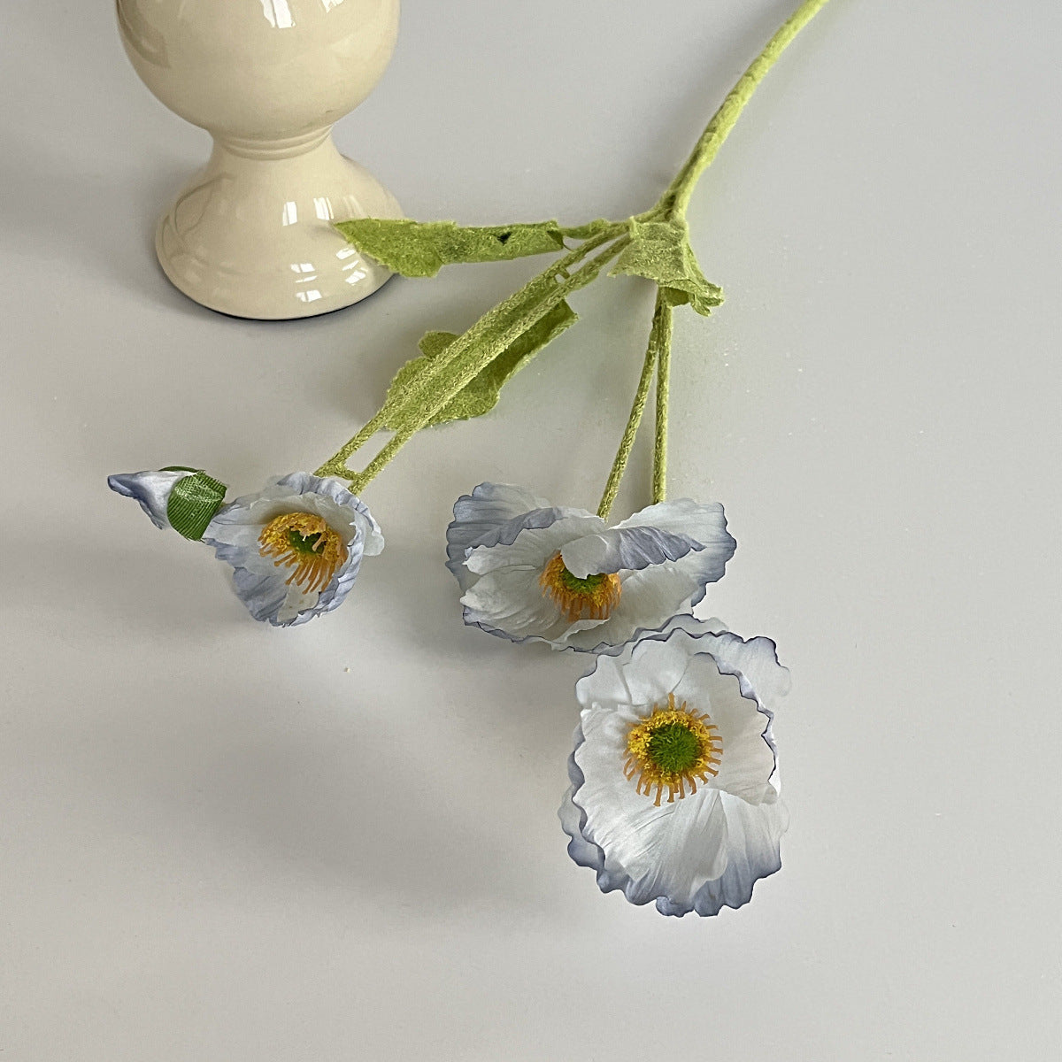 realistic faux silk poppy flowers in light blue gradient color on an aesthetic grey background