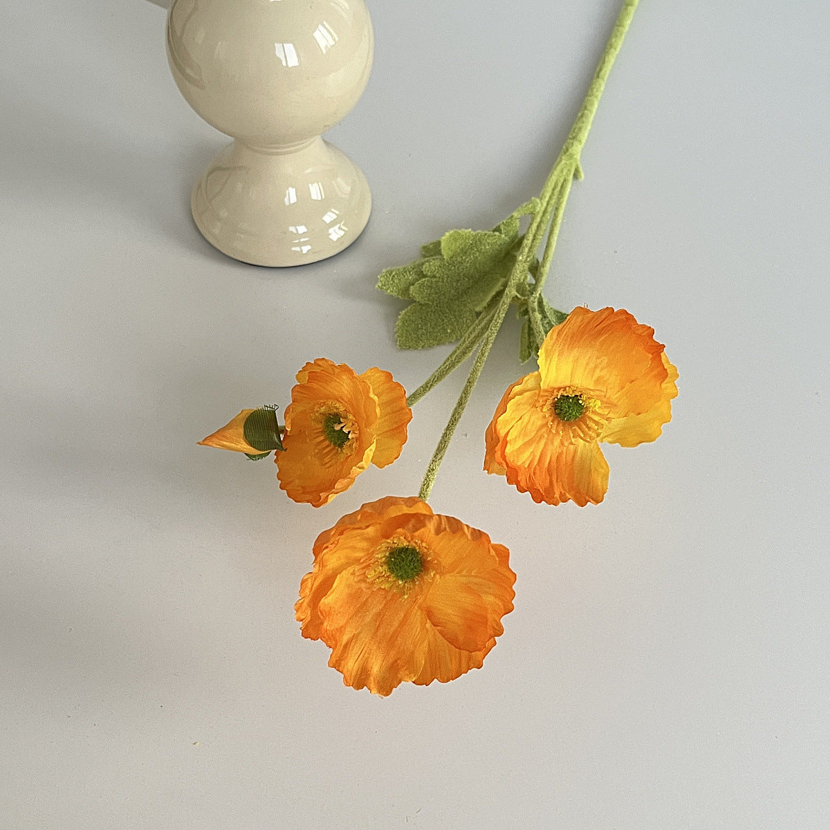 realistic faux silk poppy flowers in bright orange color on an aesthetic grey background