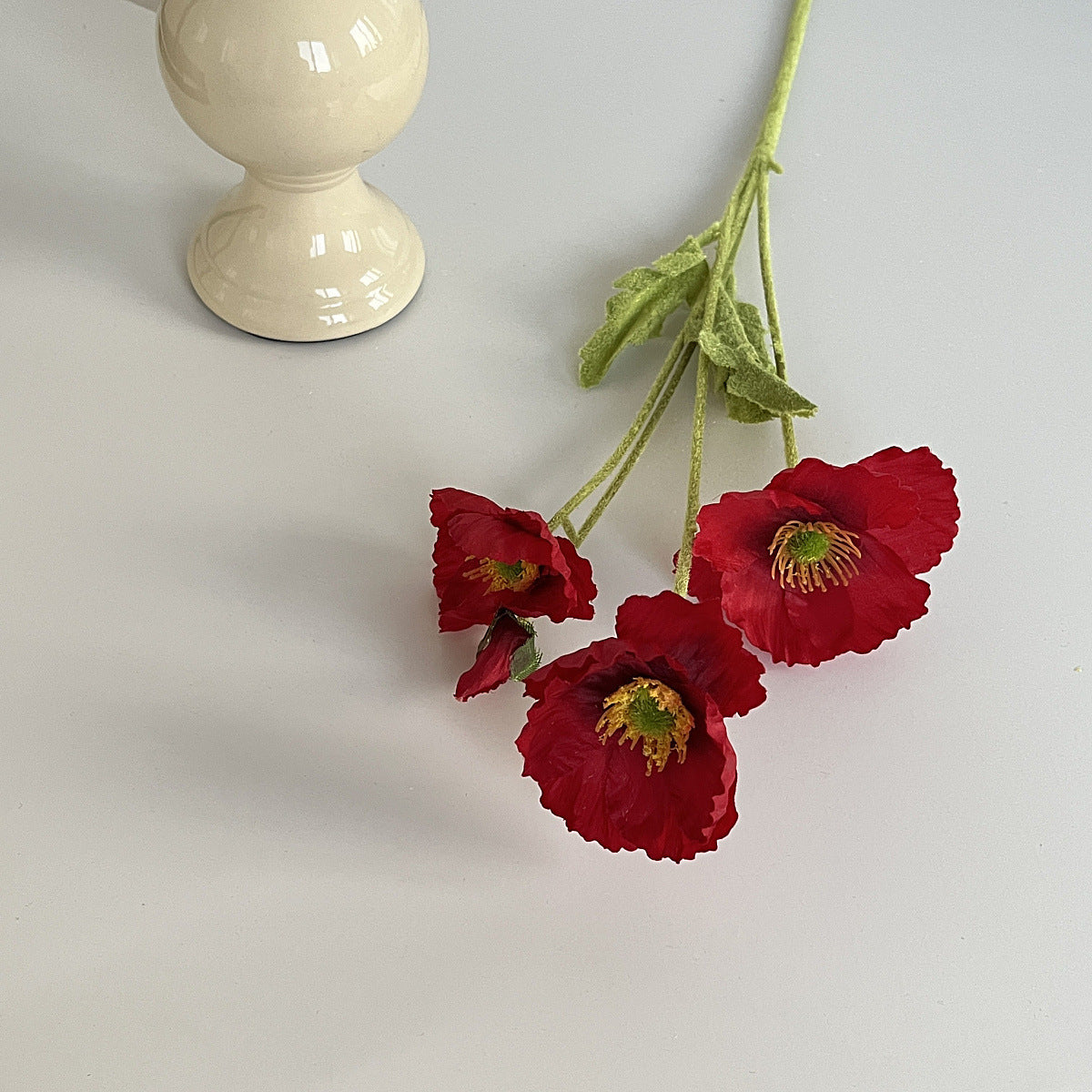 realistic faux silk poppy flowers in vintage dark red color on an aesthetic grey background