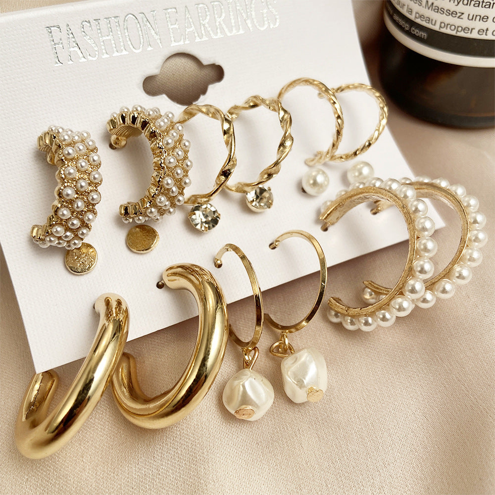 close up view of gold chunk hoop pearl earrings set displaying assorted metallic finishes and simulated baroque pearl charms