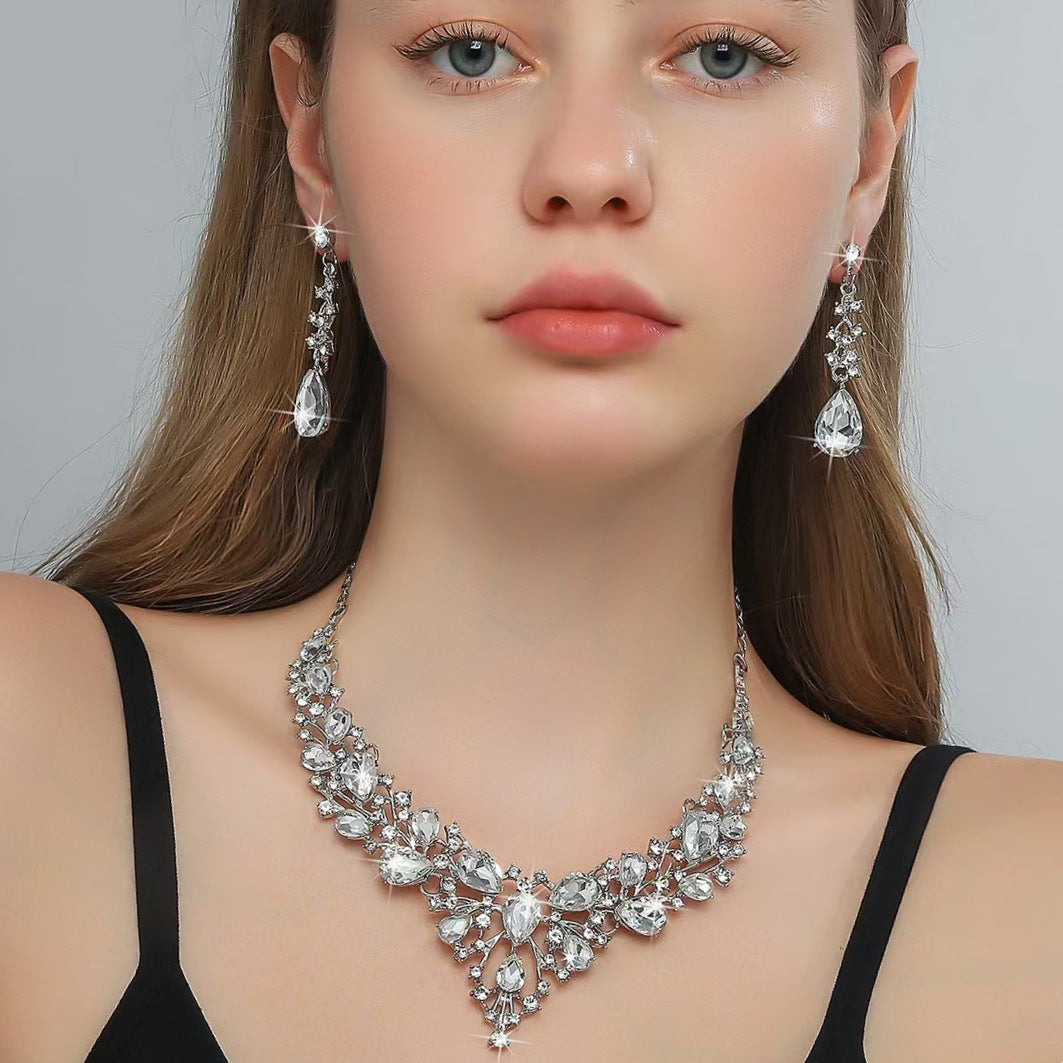 elegant waterdrop crystal bridal jewelry set in classic silver color with shimmering rhinestone necklace and teardrop dangle earrings on a model