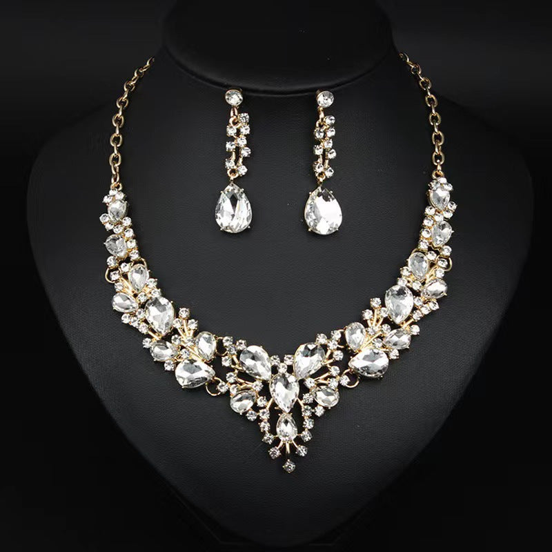 elegant waterdrop crystal bridal jewelry set in luxury gold color displayed on a black neck mannequin bust