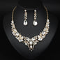 elegant waterdrop crystal bridal jewelry set in luxury gold color displayed on a black neck mannequin bust