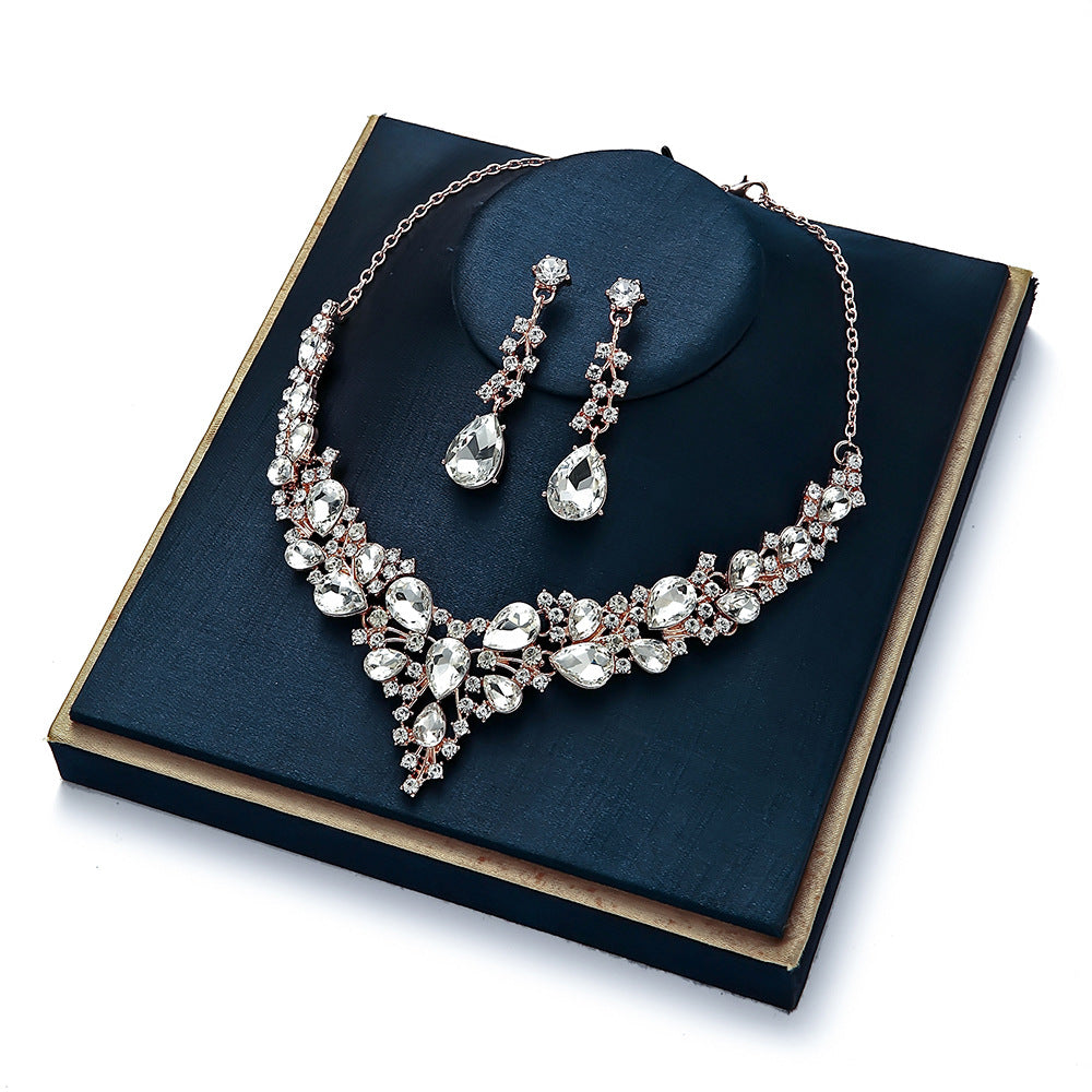 elegant waterdrop crystal bridal jewelry set in luxury gold color displayed on a premium dark blue velvet gift box