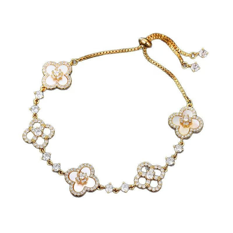 four leaf clover mother of pearl bracelet in luxury gold color with adjustable drawstring chain on a clean white background
