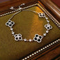 four leaf clover mother of pearl bracelet in sleek black color with silver adjustable chain on a vintage velvet tray
