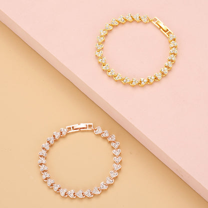 gold and rose gold heart shape tennis bracelets with sparkling iced out crystals displayed together