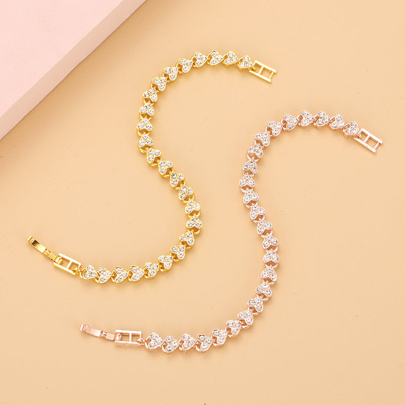 gold and rose gold heart shape tennis bracelets with sparkling iced out crystals displayed together