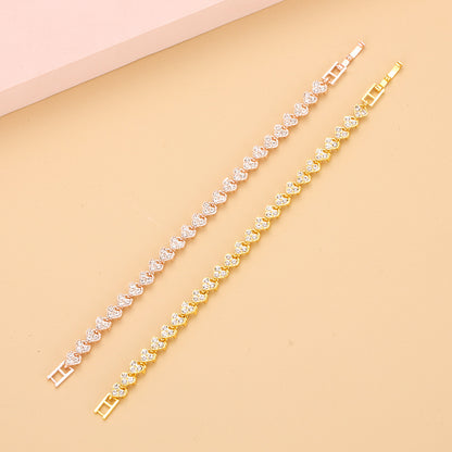 gold and silver heart shape tennis bracelets fully paved with glittering crystals aligned on an elegant background