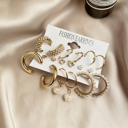 gold chunk hoop pearl earrings set displayed elegant on luxurious champagne silk satin fabric background