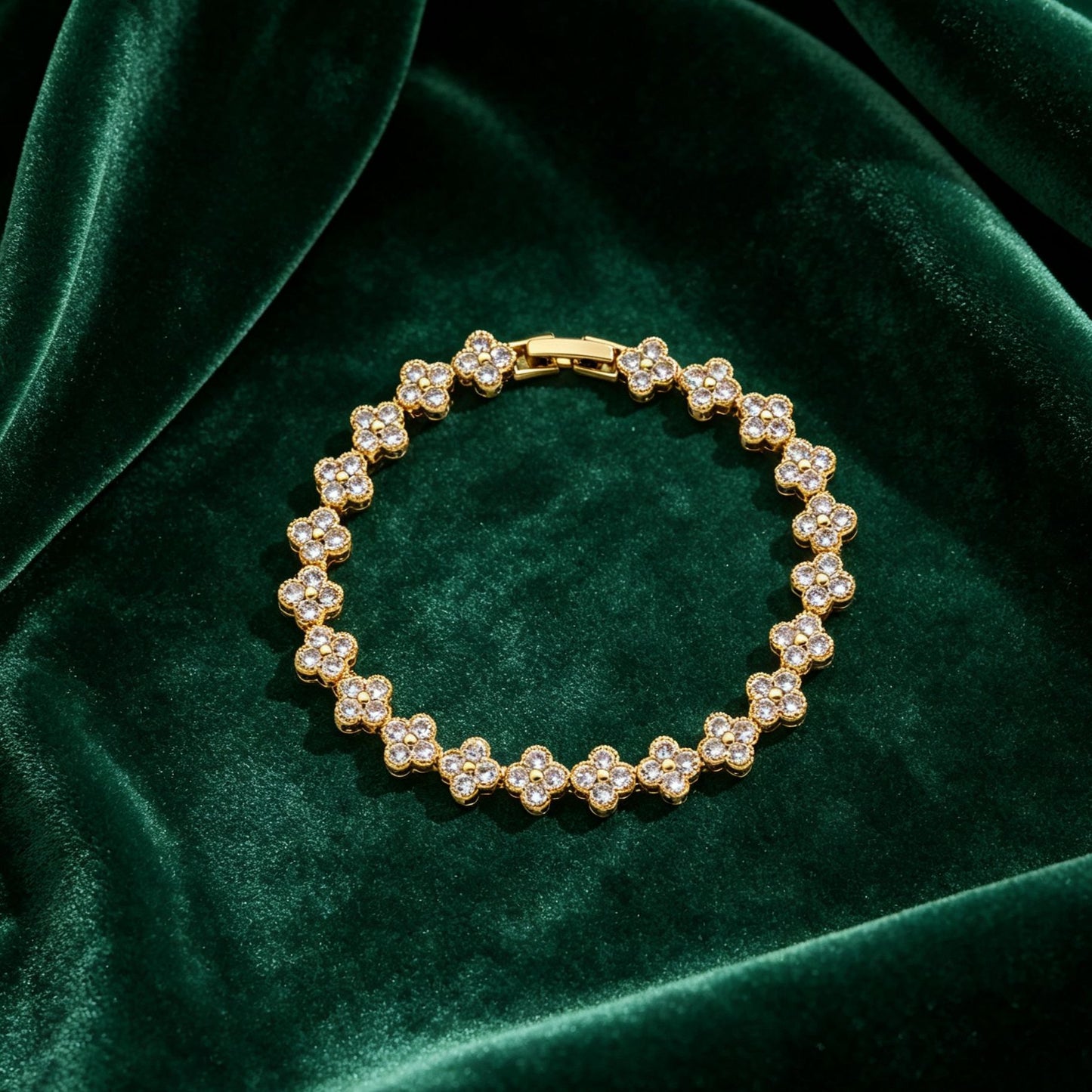 luxury four leaf clover crystal charm bracelet in shiny gold finish on dark green velvet fabric