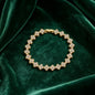 luxury four leaf clover crystal charm bracelet in shiny gold finish on dark green velvet fabric