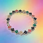 luxury four leaf clover crystal charm bracelet with multicolored iced out rhinestone gems on a vibrant gradient background