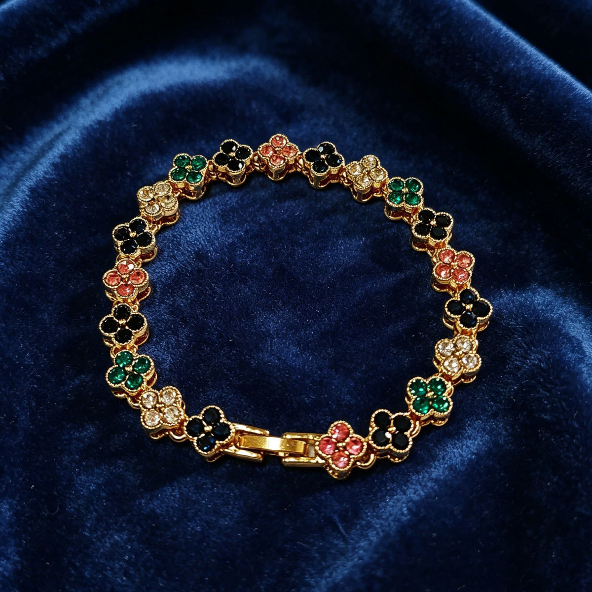 luxury four leaf clover crystal charm bracelet with multicolored iced out rhinestone gems on dark blue velvet