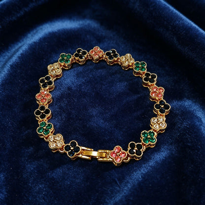 luxury four leaf clover crystal charm bracelet with multicolored iced out rhinestone gems on dark blue velvet