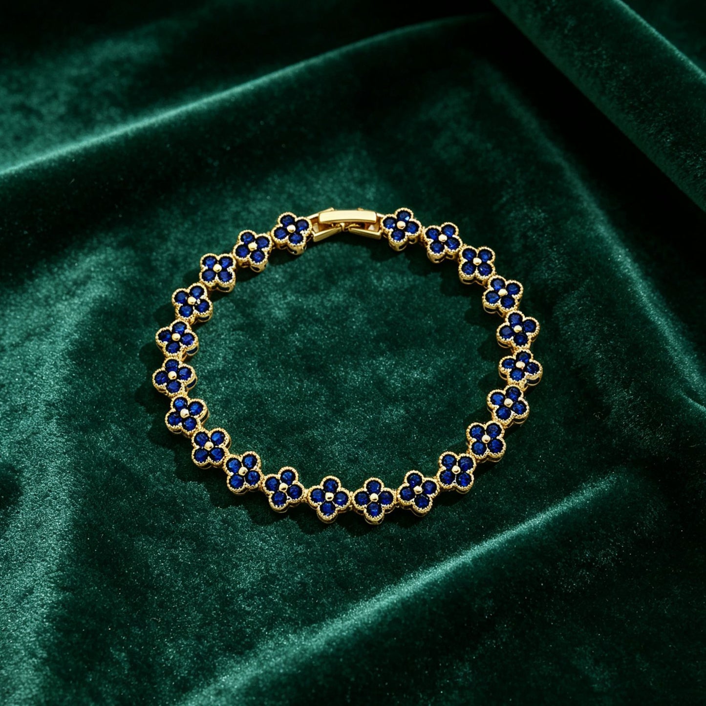 luxury four leaf clover crystal charm bracelet with royal blue rhinestone gems on dark green velvet fabric