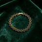 luxury four leaf clover crystal charm bracelet with sleek black rhinestone gems on dark green velvet cushion