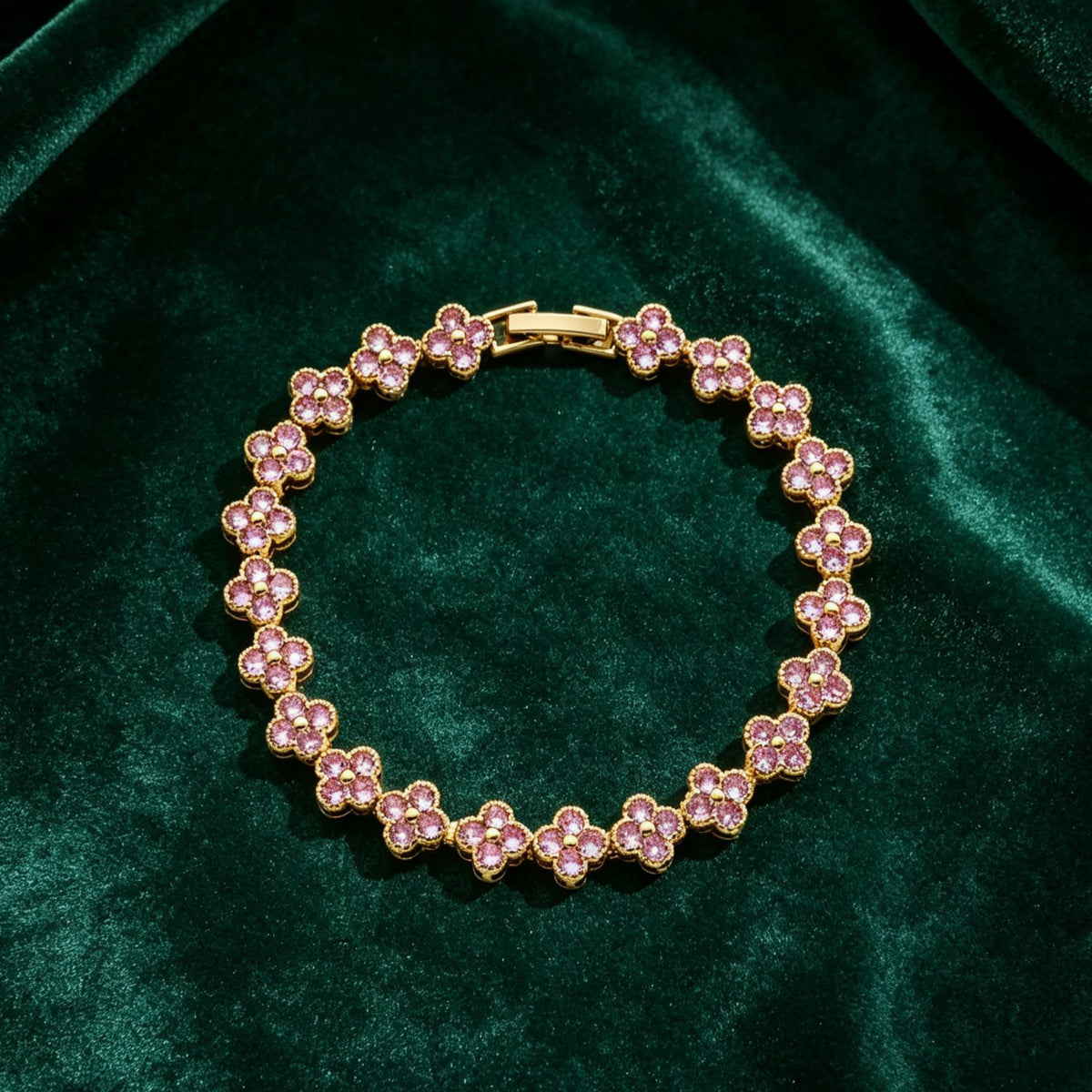 luxury four leaf clover crystal charm bracelet with soft pink rhinestone gems on dark green velvet fabric
