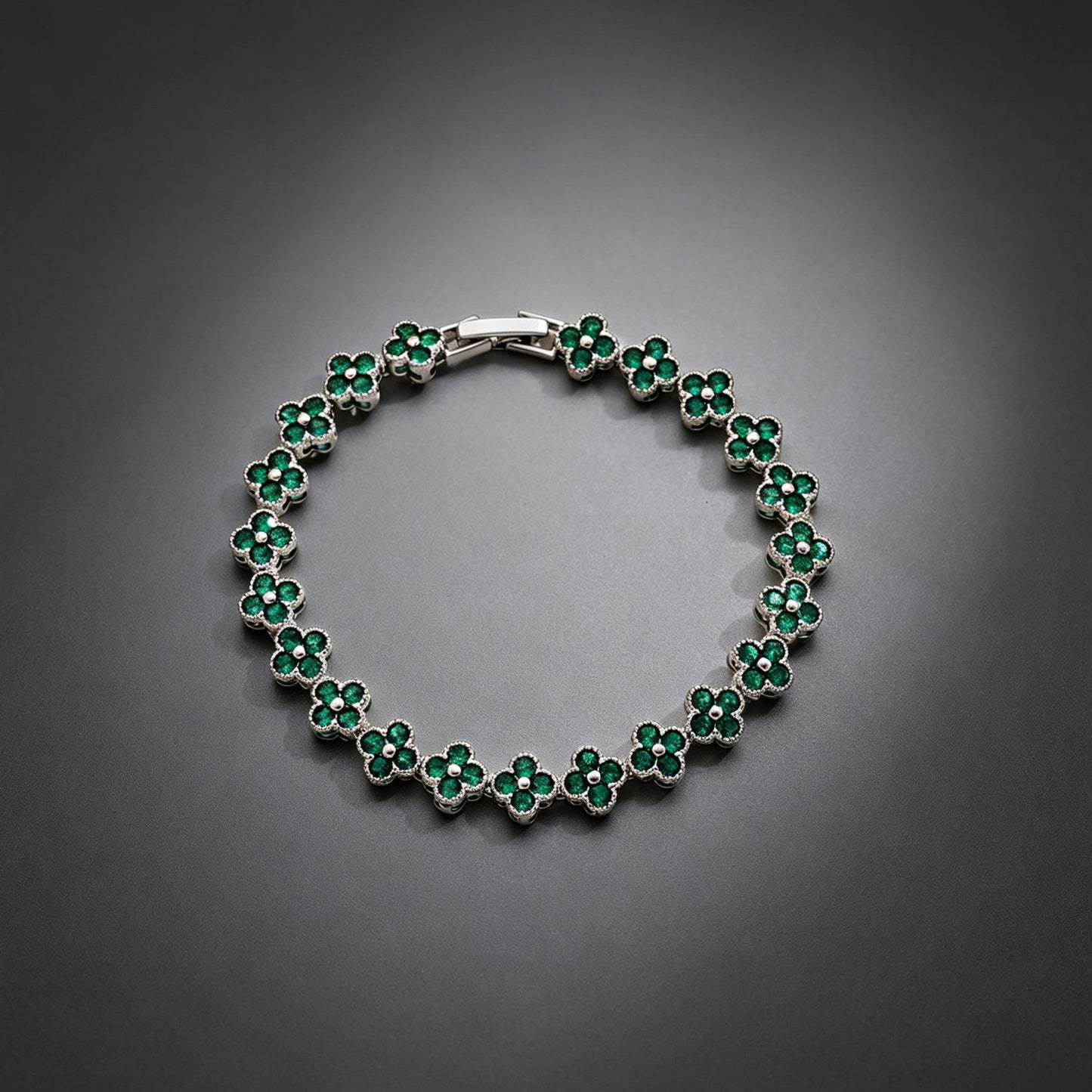 luxury four leaf clover crystal charm bracelet with vibrant emerald green rhinestone gems on a clean grey background