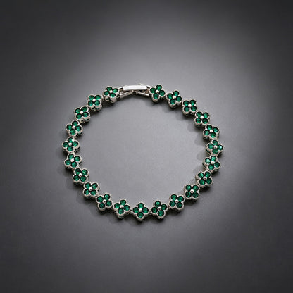 luxury four leaf clover crystal charm bracelet with vibrant emerald green rhinestone gems on a clean grey background