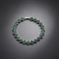 luxury four leaf clover crystal charm bracelet with vibrant emerald green rhinestone gems on a clean grey background