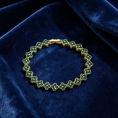 luxury four leaf clover crystal charm bracelet with vibrant emerald green rhinestone gems on dark blue velvet