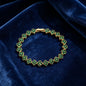 luxury four leaf clover crystal charm bracelet with vibrant emerald green rhinestone gems on dark blue velvet
