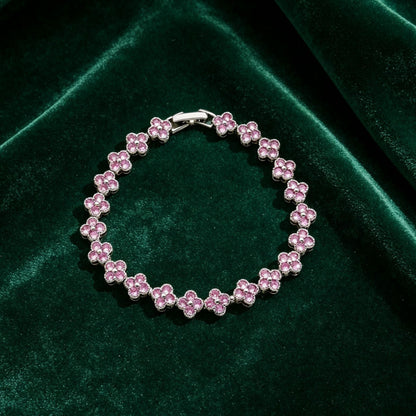 luxury four leaf clover rhinestone charm bracelet with sparkling pink crystals on dark green velvet