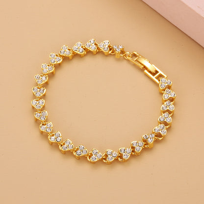 luxury gold heart shape tennis bracelet fully paved with sparkling crystal stones on an elegant backdrop